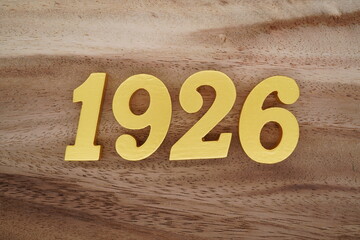 Golden Arabic numerals on a real brown and white wooden floor number 1926