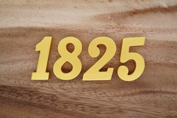 Golden Arabic numerals on a real brown and white wooden floor number 1825