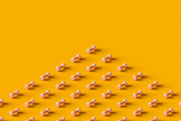 pink dumbbells on an orange background. 3d render.