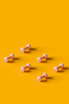 pink dumbbells on an orange. sports equipment.