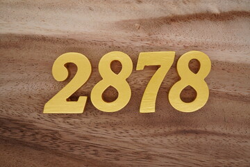 Golden Arabic numerals on a real brown and white wooden floor number 2878