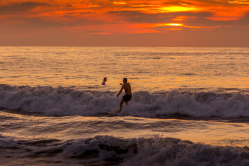 Person Surfing at Sunrise