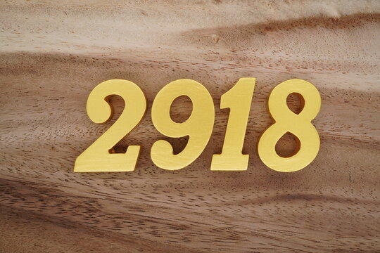 Golden Arabic numerals on a real brown and white wooden floor number 2918