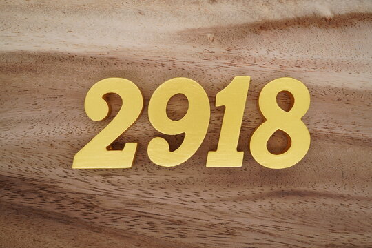 Golden Arabic numerals on a real brown and white wooden floor number 2918