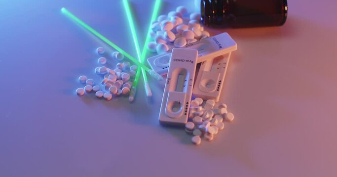 Coronavirus rapid test with medicine pills rotating on white background. Green probes with quick test sticks