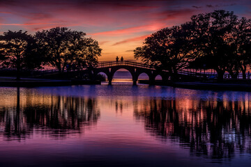 People on a bridge watching a sunset