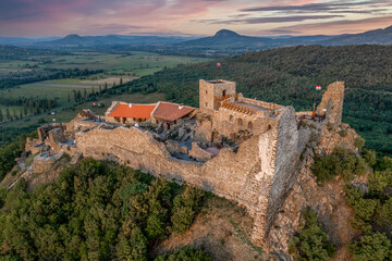 Fototapeta na wymiar Aerial view of Szigliget castle near lake Balaton with newly restored walls, gate tower, palace building sunset colorful sky