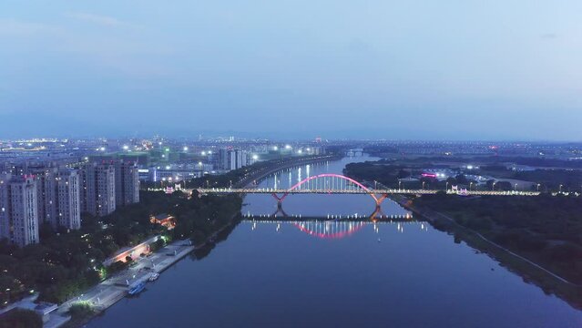 aerial view of grand bridge over river in quzhou at night
