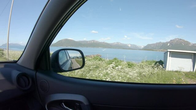POV from car window. Beautiful shot of sea mountain and grass view from car windows.