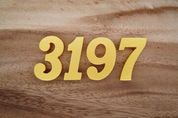 Golden Arabic numerals on a real brown and white wooden floor number 3197