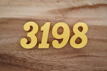 Golden Arabic numerals on a real brown and white wooden floor number 3198