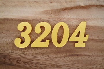 Golden Arabic numerals on a real brown and white wooden floor number 3204