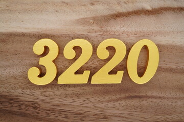 Golden Arabic numerals on a real brown and white wooden floor number 3220