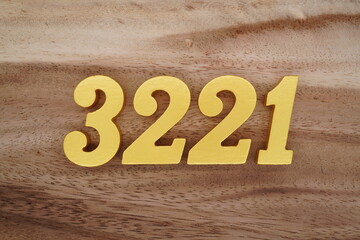 Golden Arabic numerals on a real brown and white wooden floor number 3221