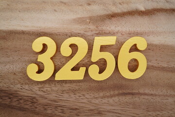 Golden Arabic numerals on a real brown and white wooden floor number 3256