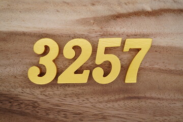 Golden Arabic numerals on a real brown and white wooden floor number 3257