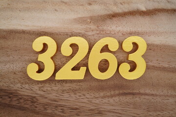 Golden Arabic numerals on a real brown and white wooden floor number 3263