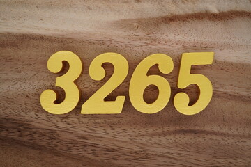 Golden Arabic numerals on a real brown and white wooden floor number 3265