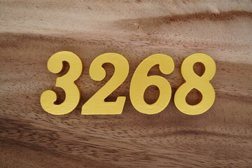 Golden Arabic numerals on a real brown and white wooden floor number 3268