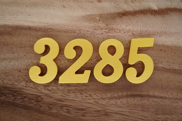 Golden Arabic numerals on a real brown and white wooden floor number 3285