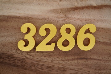 Golden Arabic numerals on a real brown and white wooden floor number 3286