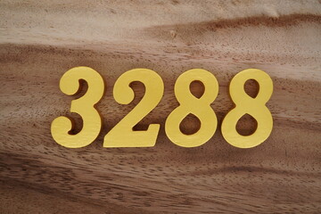 Golden Arabic numerals on a real brown and white wooden floor number 3288