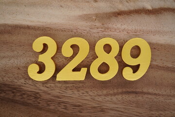 Golden Arabic numerals on a real brown and white wooden floor number 3289