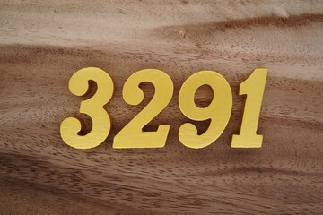 Golden Arabic numerals on a real brown and white wooden floor number 3291