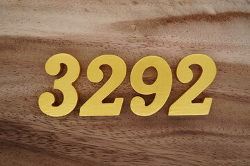 Golden Arabic numerals on a real brown and white wooden floor number 3292