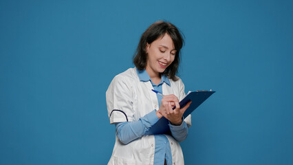 Female scientist taking notes on clipboard documents, writing formula results for chemistry analysis. Chemcial researcher using papers to do laboratory experiment for science study.