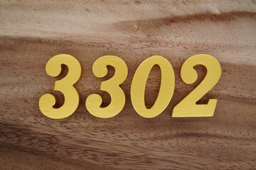 Golden Arabic numerals on a real brown and white wooden floor number 3302