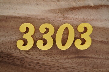 Golden Arabic numerals on a real brown and white wooden floor number 3303