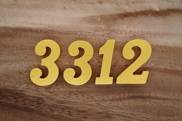 Golden Arabic numerals on a real brown and white wooden floor number 3312