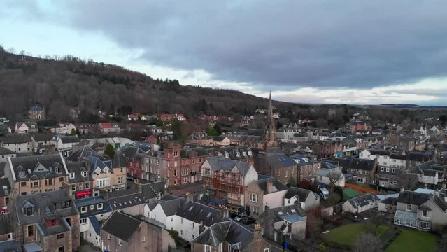 Drone footage. Ascending over the town of Callander, Scotland, Highlands. A church in the center of the town