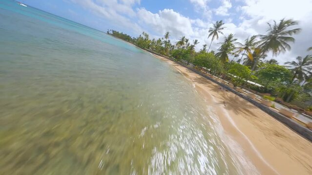 Crazy racing drone flight over playa Punta Popy at Las Terrenas in Dominican Republic. Aerial forward
