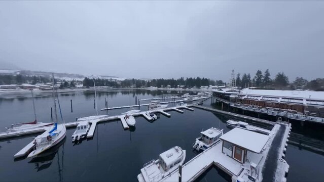 Overview Towards the Shores of a Snow-Covered Marina in Sechelt Inlet British Columbia Canada - Forward Panning Drone Shot 1080p 60 frames per second