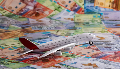 Model of a passenger plane  on the background of Kazakhstani banknotes - tenge