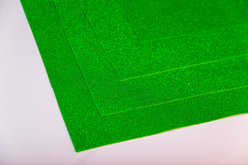 Green Sheets of cardboard with sparkles on a white background.