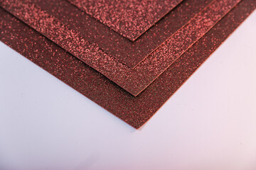Brown sheets of cardboard with glitter on a white background.