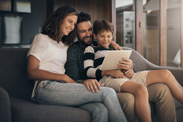 Share the love, share the fun. Shot of an adorable little boy using a digital tablet with his...