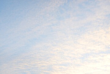 Clear blue sky, glowing pink and golden clouds after storm at sunset. Dramatic cloudscape. Moon,...