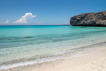 Landscape, seascape of a beautiful Mexican sandy beach, with mountains clouds in the background, a blue sky and turquoise water. concept of vacations and nature, horizontal view