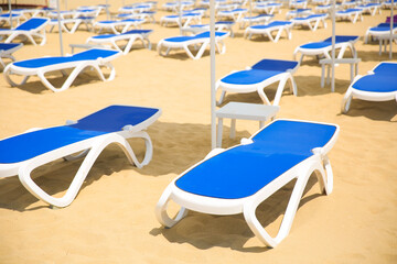 empty sun loungers on the beach on a sunny summer day