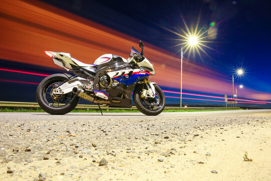 Stupino/Russia - AUGUST 29, 2019 motorbike bmw s1000rr on the night road. BMW motorcycle on a night highway against the background of lights of passing cars. superbike in the lights of motion cars
