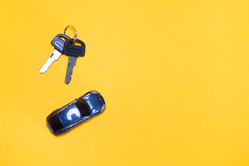 Ivanovo, Russia - 03.03.2022:miniature of car and bunch of keys from it lies on yellow background: purchase of movable property in conditions of currency exchange rate changes, import substitution