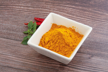 Yellow vibrant curcuma powder in the bowl