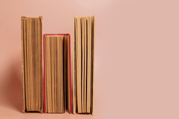 A stack of old worn books on a colored background