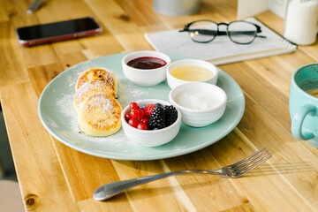 Healthy summer breakfast. Cottage cheese pancakes with fresh berries, cappuccino coffee