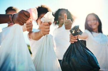 Reporting for cleanup duty. Shot of a group of teenagers picking up litter off a field and showing thumbs up at summer camp.