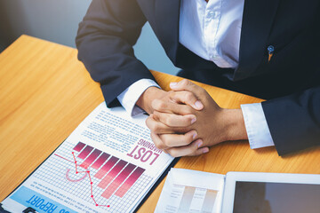 Bad investment or economic crisis concept. Crop image of businessman's hands holding from business disappointed and seriously by bad business results report. Selected focus.